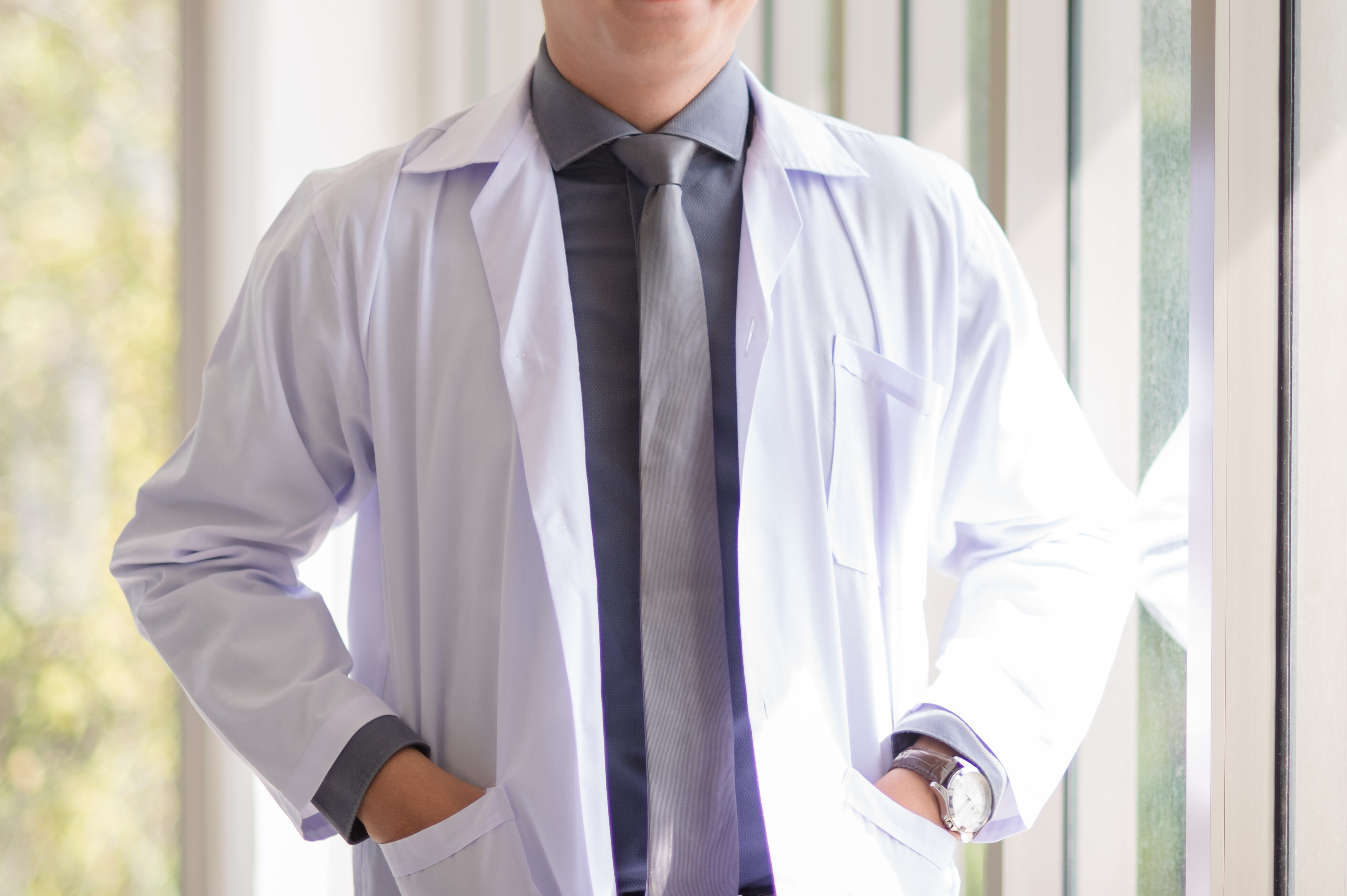 Asian doctor man portrait in professional uniform standing with smile and confidence.